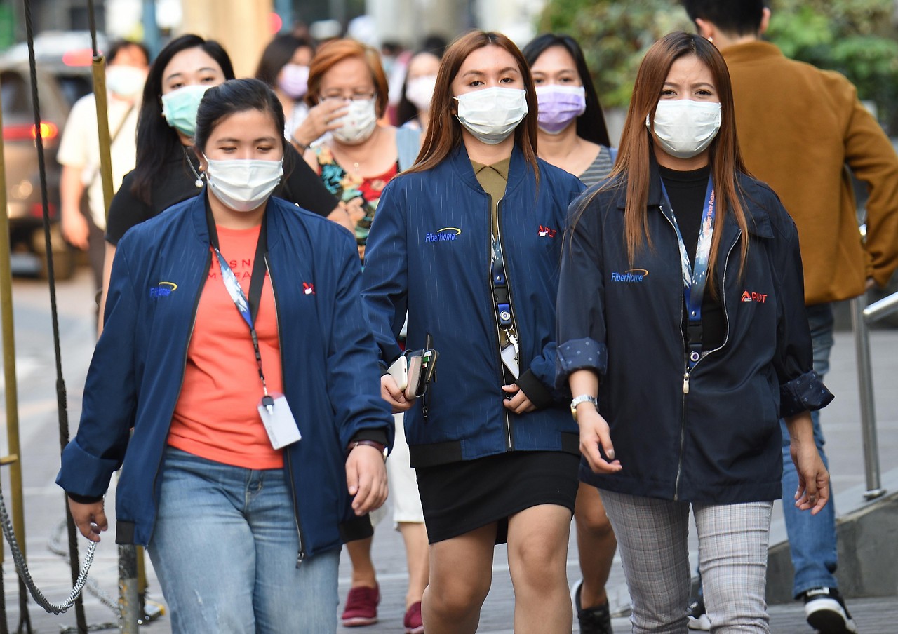 Büroangestellte in Manila mit Mundschutz