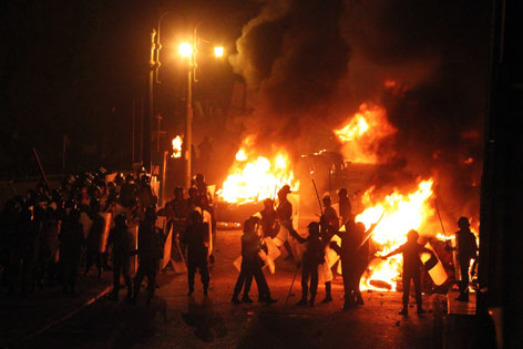 Koptische Demonstranten treffen in Kairo zwischen brennenden Autos auf Sicherheitskräfte.
