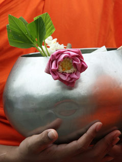 Buddhistische Opferschale in der Hand eines Mönchs