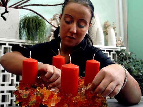 Eine Floristin bindet einen Gummibär-Adventkranz.