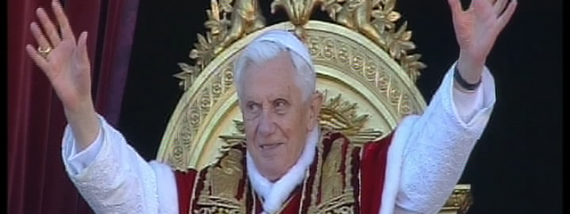 Papst Benedikt XVI. hebt grüßend und lächelnd die Hände