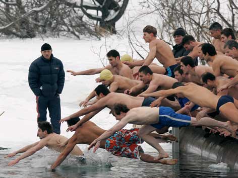 Männer springen in das Wasser eines gefrorenen Sees in Bulgarien.