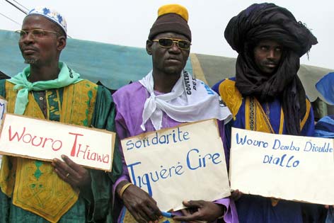 Senegalesische Männer mit Transparenten gegen die weiblische Genitalverstümmelung