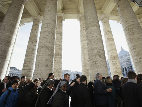 Eine Menschenschlange im Säulengang am Petersplatz wartet vor Beginn der letzten Aschermittwochsliturgie mit Benedikt XVI.