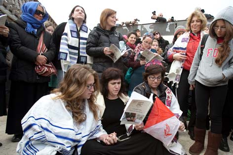 Jüdische Frauen sitzen und stehen vor der Klagemauer in Jerusalem um für das gleichberechtigte Tragen von Gebetsschals einzutreten.