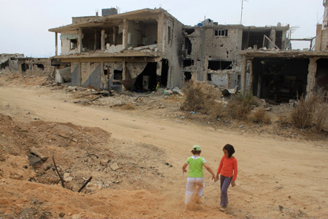 Zwei Kinder vor der Ruine eines Hauses in Qusair