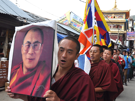 Exiltibeter tragen ein Bild des Dalai Lama durch die Straßen