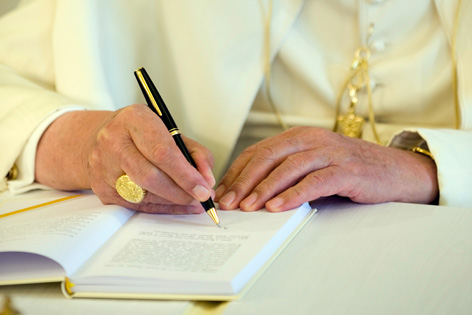 Die Hände von Papst Benedikt XVI. während der Unterzeichnung der Enzyklika "Caritas in Veritate"