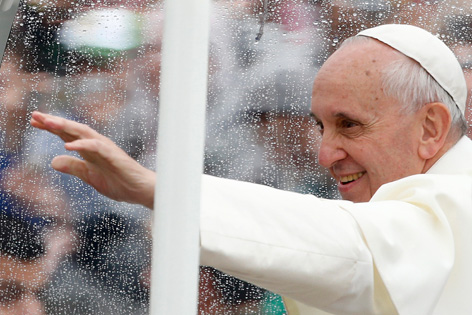 Papst Franziskus winkt bei starkem Regen aus dem Auto