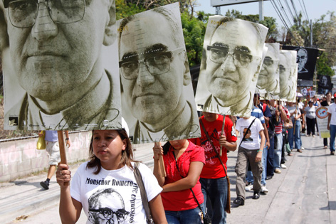 Prozession von Gläubigen mit Romero-Schildern