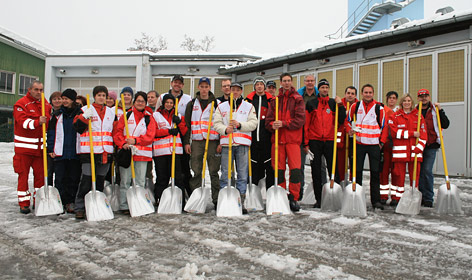 Team Österreich Mitglieder beim Schneeschaufeln