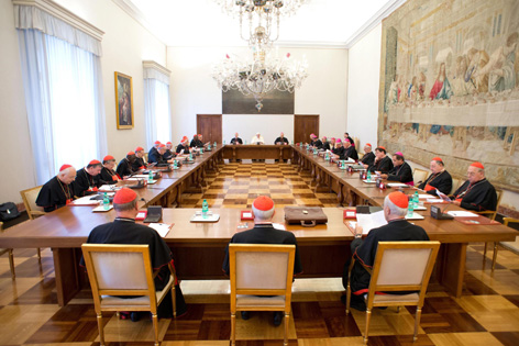 Papst Franziskus und Kardinäle sitzen an in einem Viereck angeordneten Tischen