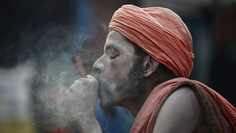 Ein Sadu raucht Marihuana zum Shivaratri Festival