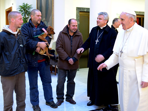 Papst Franziskus mit vier Obdachlosen
