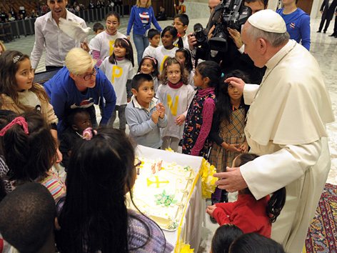 Papst Franziskus bekommt von einer Gruppe Kinder eine Geburtstagstorte