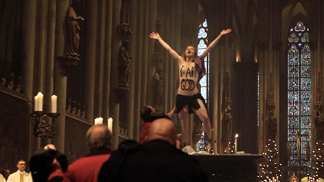 Eine Femen-Aktivistin steht nackt am Altar des Kölner Doms