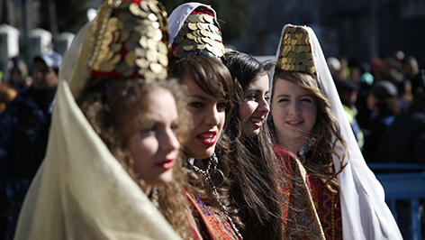 Junge Frauen tragen bei der Weihnachtsprozession von Jerusalem nach Bethlehem zur Geburtskirche traditionelle Tracht.