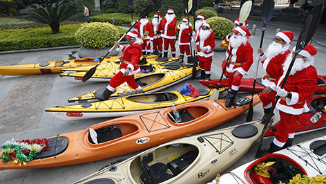 Mitglieder des Kayak Clubs in der Elfmillionenstadt Guangzhou, im Süden der Volksrepublik China, feiern Weihnachten mit einer Ruderpartie in Santa Claus Kostümen am nahen Zhujiang Fluss.