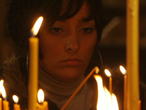 Orthodoxe Weihnachten: Eine Frau entzündet Kerzen