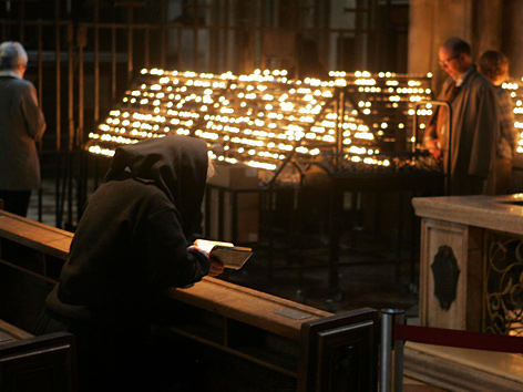 Gläubige beten und zünden Kerzen im Stephansdom in Wien an