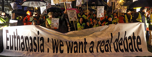 Demonstranten mit Plakat mit der Aufschrift "Euthanasia: We want a real debate"