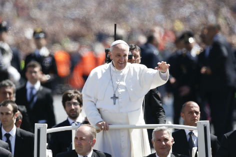 Papst Franziskus umgeben von Sicherheitskräften im Papamobil auf dem Petersplatz