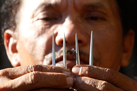 Ein Jesus-Darsteller zeigt die Metallnägel, mit denen sich Philippinos zu Ostern an Kreuze nageln lassen