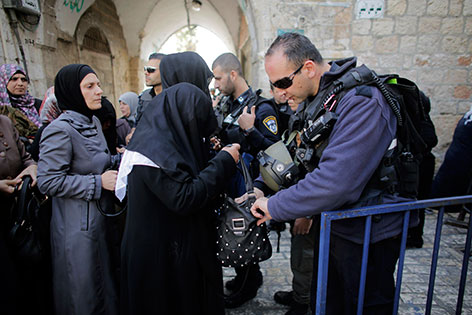 Polizisten durchsuchen die Taschen von Frauen, die durch eine Absperrung auf dem Jerusalemer Tempelberg gehen wollen