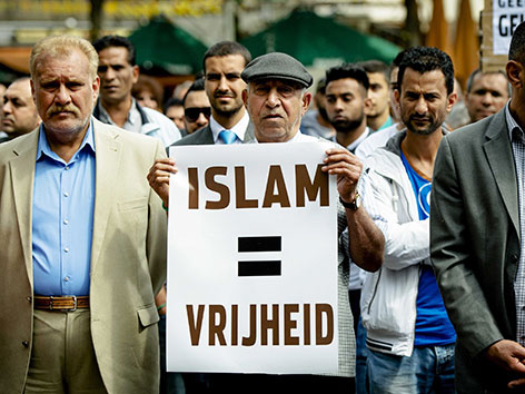 Muslimische Männer demonstrieren gegen ISIS mit Plakaten "Islam ist Freiheit"