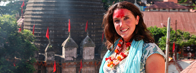 Historikerin Bethany Hughes mit roter Farbe im Gesicht vor einem Tempel in Indien