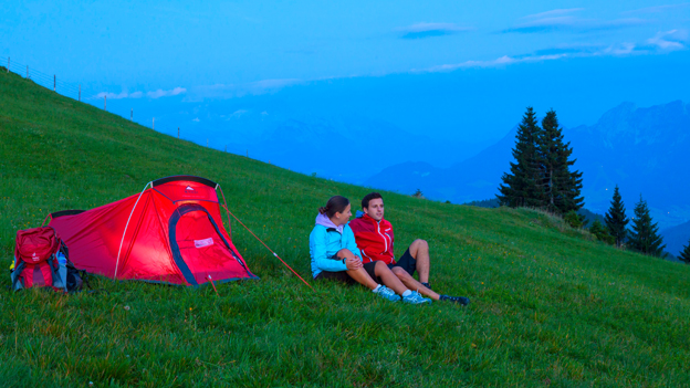 Ein Paar sitzt vor einem Campingzelt