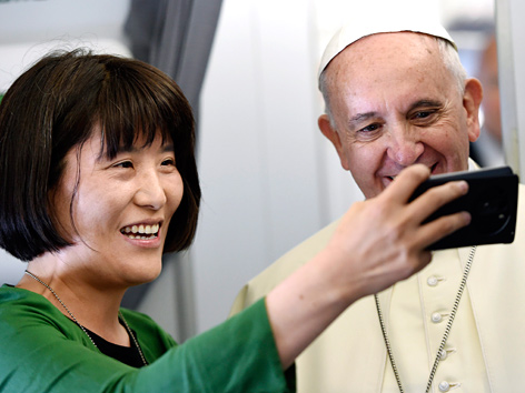 Papst Franziskus posiert für ein Foto mit einer koreanischen Journalistin