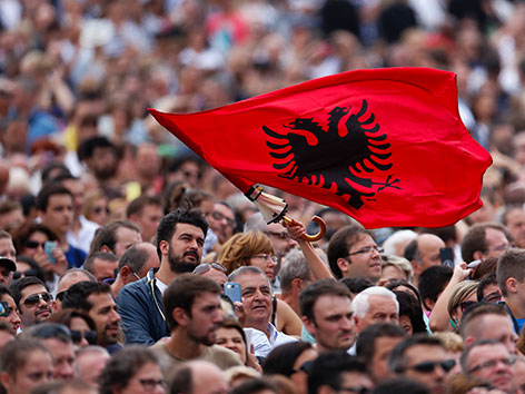 Gläubige auf dem Petersplatz schwenken eine albanische Fahne