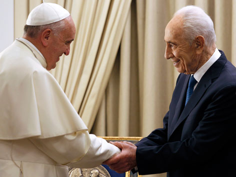 Papst Franziskus und Shimon Peres schütteln einander die Hand