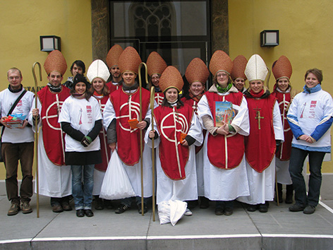 Mehrere junge Frauen und Männer mit Bischofshüten als Hl. Nikolaus verkleidet