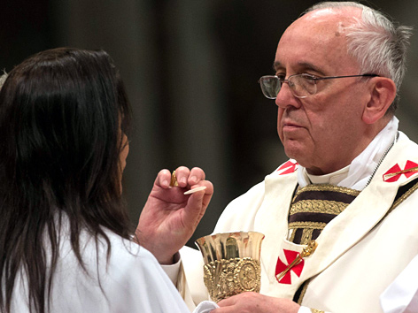 Papst Franziskus erteilt einer Gläubigen die Kommunion