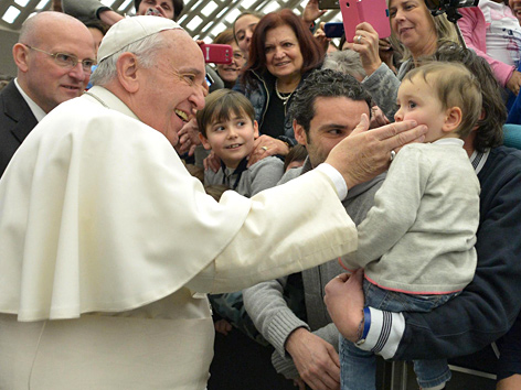 Papst Franziskus streichelt ein Kind während einer seiner Generalaudienzen