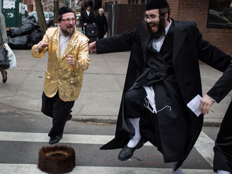 Ausgelassen tanzende jüdische Männer auf den Strassen New Yorks (Purim)