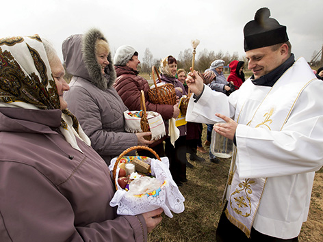 Ostern 2015. Ein katholischer Priester segnet Speisen. Krutilovichi bei Minsk.
