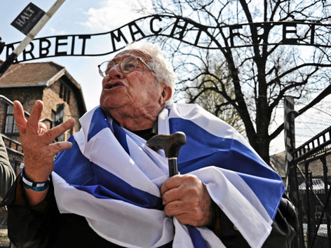 Ein Holocaust-Überlebender spricht vor dem Eingang zum KZ Auschwitz