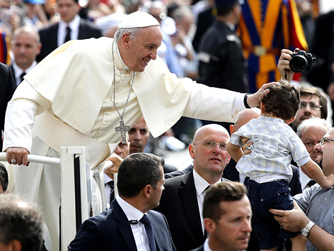 Papst Franziskus streichelt ein Kind während einer Generalaudienz auf dem Petersplatz