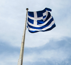 Eine griechische Fahne vor wolkigem Himmel