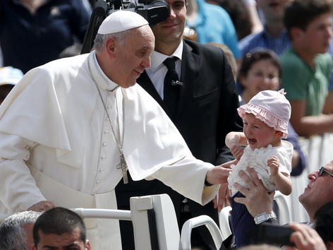 Papst Franziskus segnet ein Kind bei der Generalaudienz