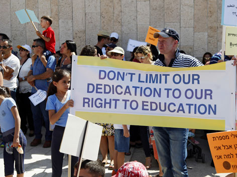 Demonstranten mit Schildern für gleiche Finanzierung christlicher und jüdisch-orthodoxer Schulen
