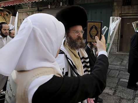Eine Palästinenserin hält bei Protesten gegen die israelische Polizei einen Koran hoch. Im Hintergrund ein jüdischer Gläubiger.