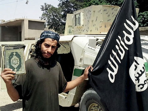 Ein Kämpfer des "Islamischen Staates" mit Koran und IS-Fahne