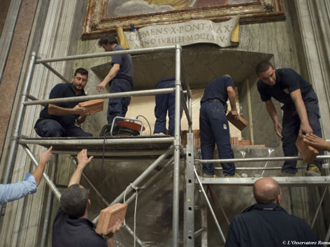 Arbeiter legen die "Heilige Pforte" im Petersdom in Rom frei