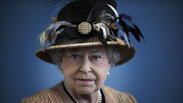 Die Queen mit einem Hut aus braunen Vogelfedern