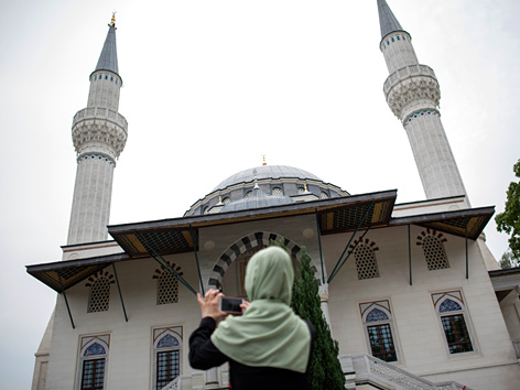 Eine verschleierte Frau nimmt ein Foto von der Sehitlik-Moschee in Berlin auf