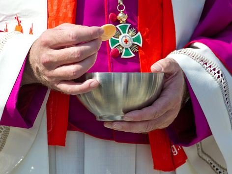 Ein Bischof verteilt beim Abschlussgottesdienst des deutschen Katholikentages Hostien
